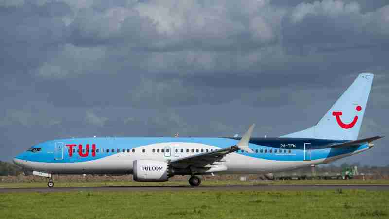 TUI Airlines jet taxiing on runway against cloudy sky, captured in daylight., tags: group – - pexel